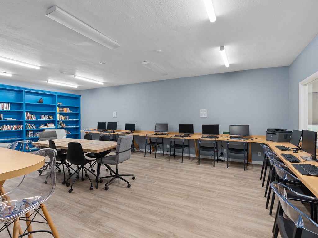an empty classroom with desks and chairs and a library