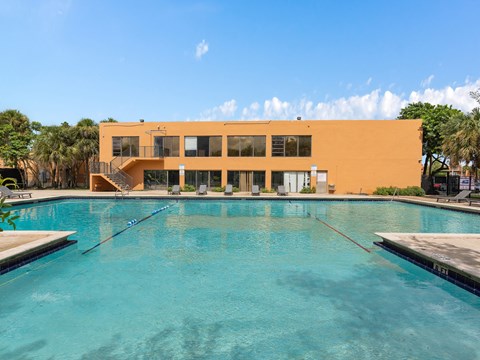 a swimming pool with a building in the background at Cypress Grove, Lauderhill, 33313