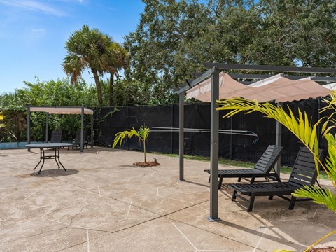 a patio with two chairs and a canopy at Cypress Grove, Lauderhill, FL