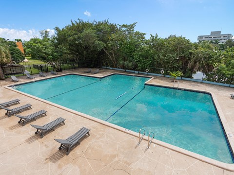 a swimming pool with lounge chairs next to a pool at Cypress Grove, Lauderhill, FL