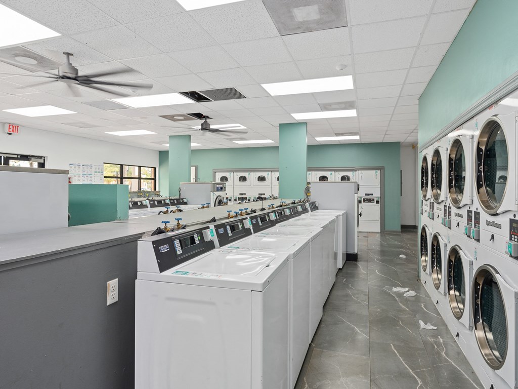 a row of washers and dryers in a laundry room