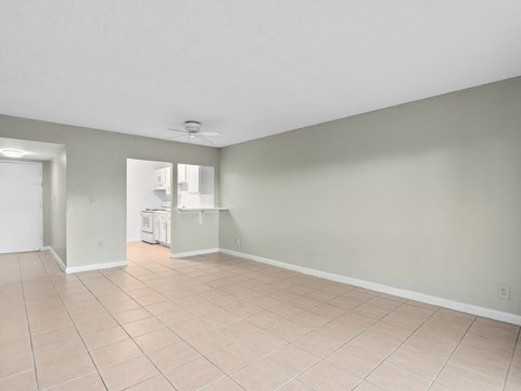 the living room and kitchen of an empty house with a tiled floor at Cypress Grove, Lauderhill, 33313