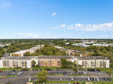 an aerial view of an apartment complex with a parking lot and trees at Cypress Grove, Lauderhill, 33313