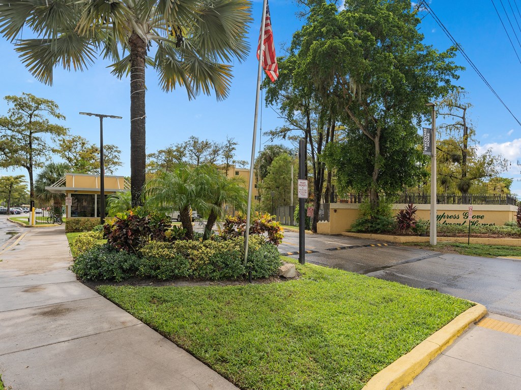 a street with a flag in front of a building with palm trees