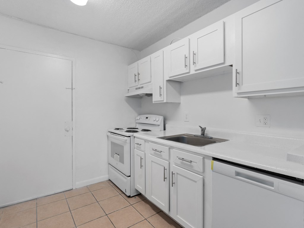 a white kitchen with white cabinets and a sink