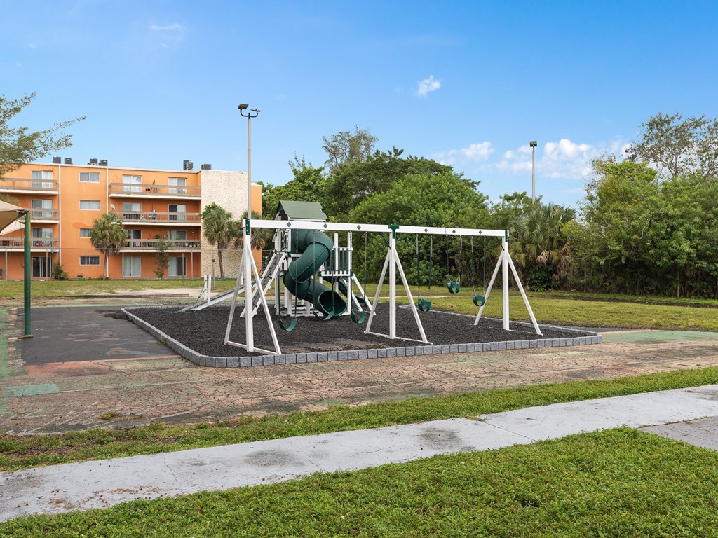 a swing set in a park in front of a building