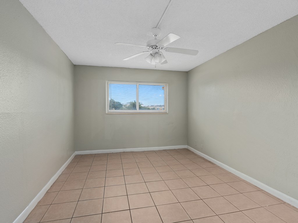 an empty room with a tile floor and a window