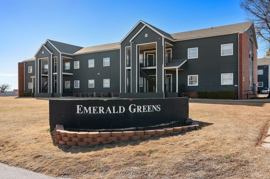 a sign that says emerald greens in front of a building