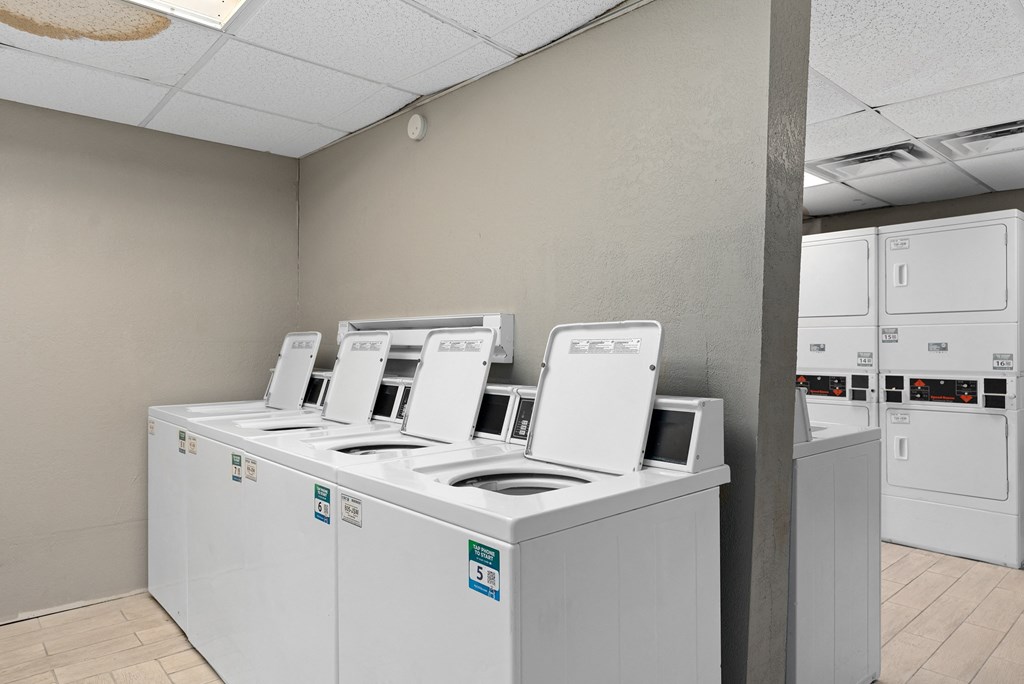 a row of washers and dryers in a laundry room
