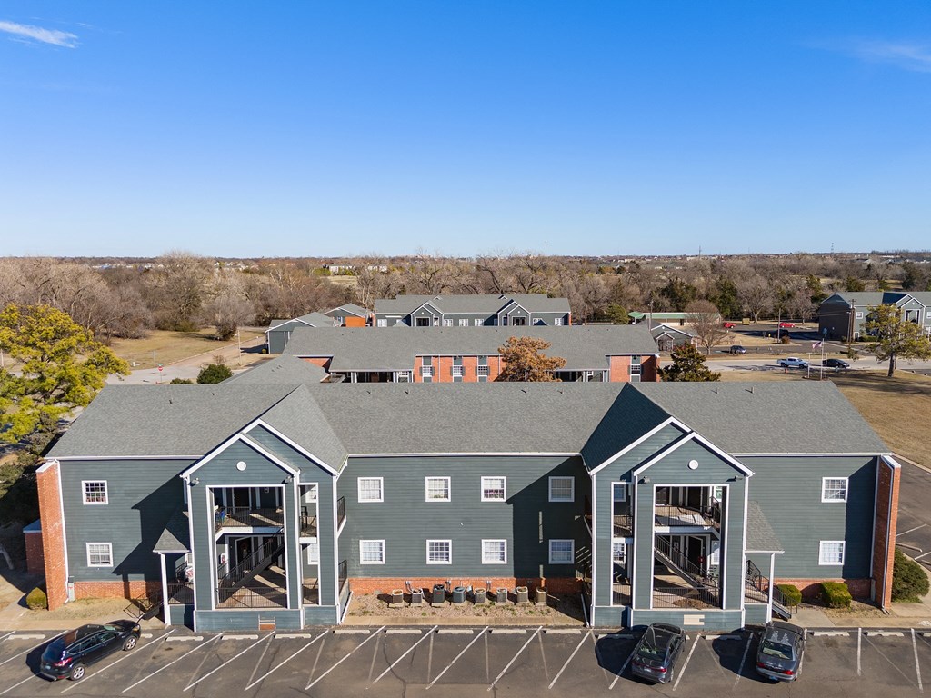 a view of a building from above with cars parked in a parking lot