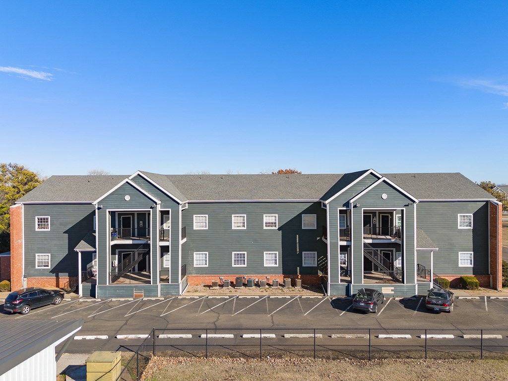 an aerial view of an apartment building with a parking lot