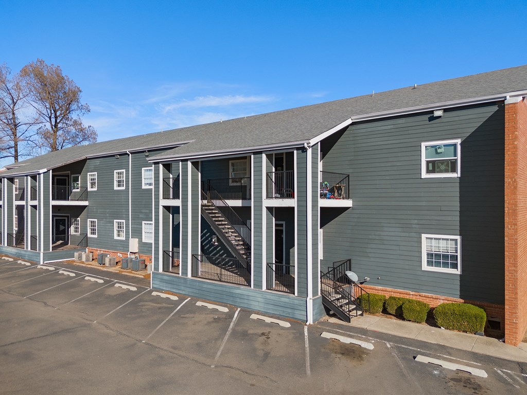 an exterior view of a gray building with a porch and stairs