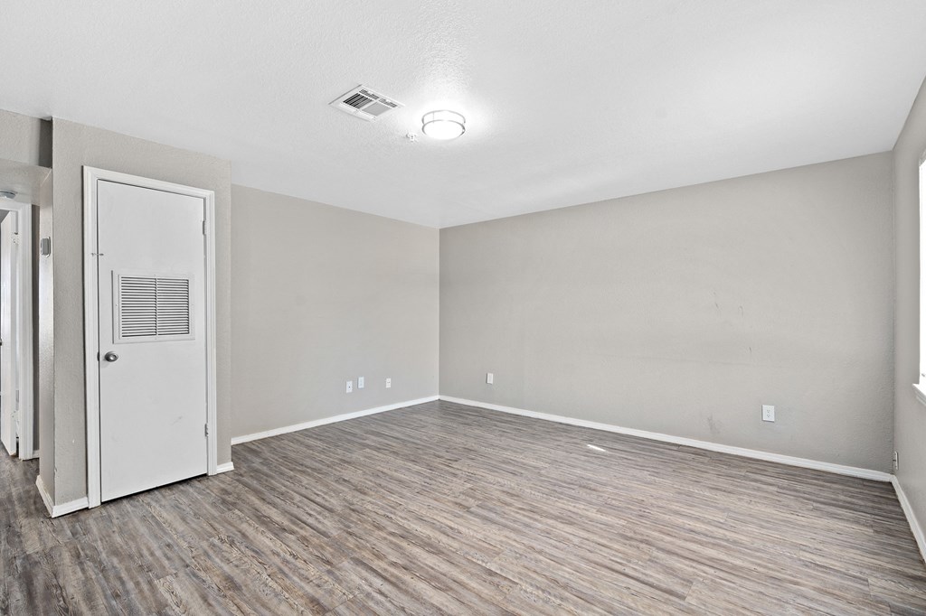 the living room of an empty apartment with wood flooring