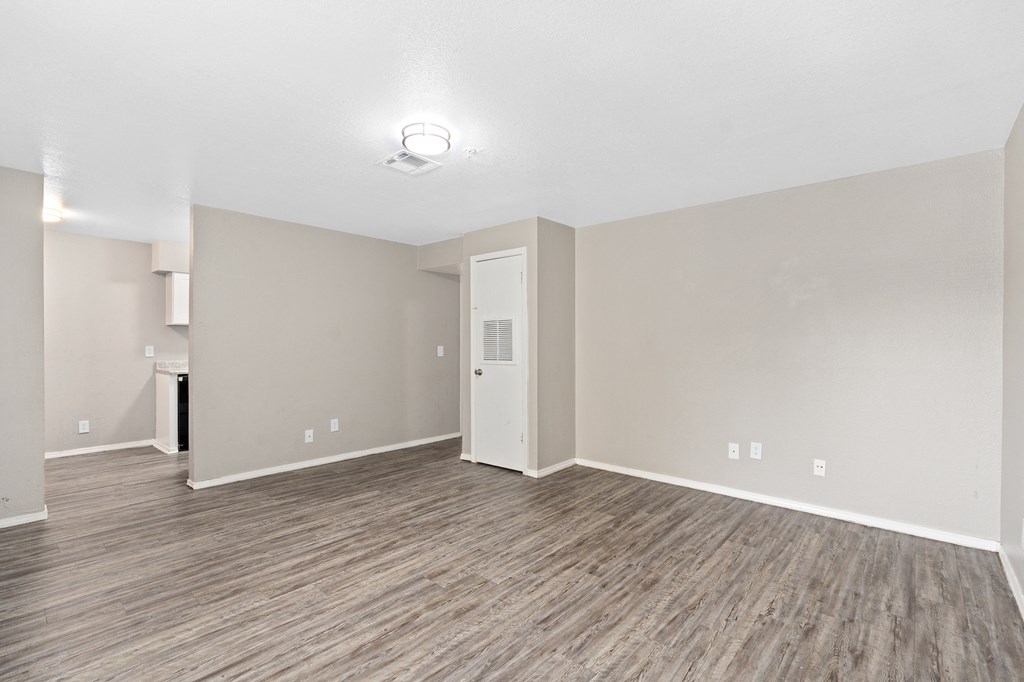 an empty room with white walls and a wood floor