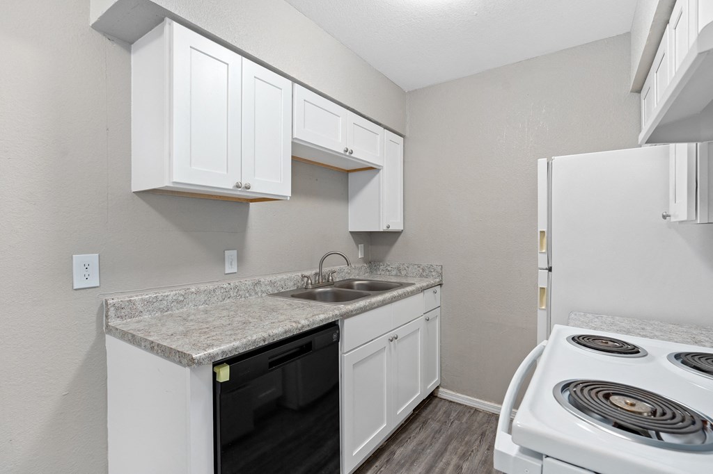 a kitchen with white cabinets and appliances and a white stove and refrigerator