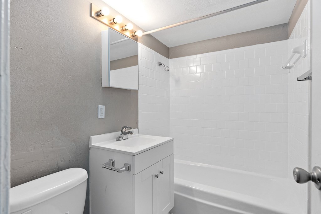 a bathroom with a sink and a tub and a mirror