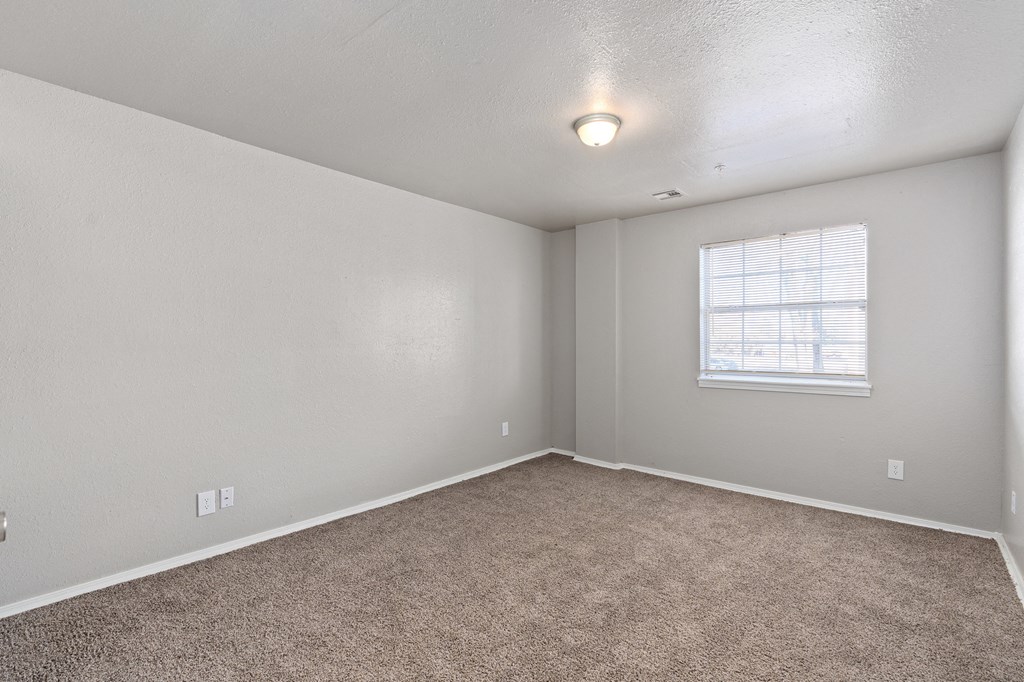 an empty room with carpet and a window