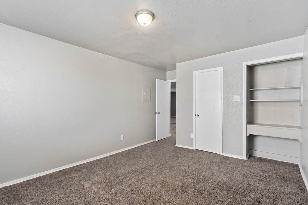 an empty room with carpet and a closet