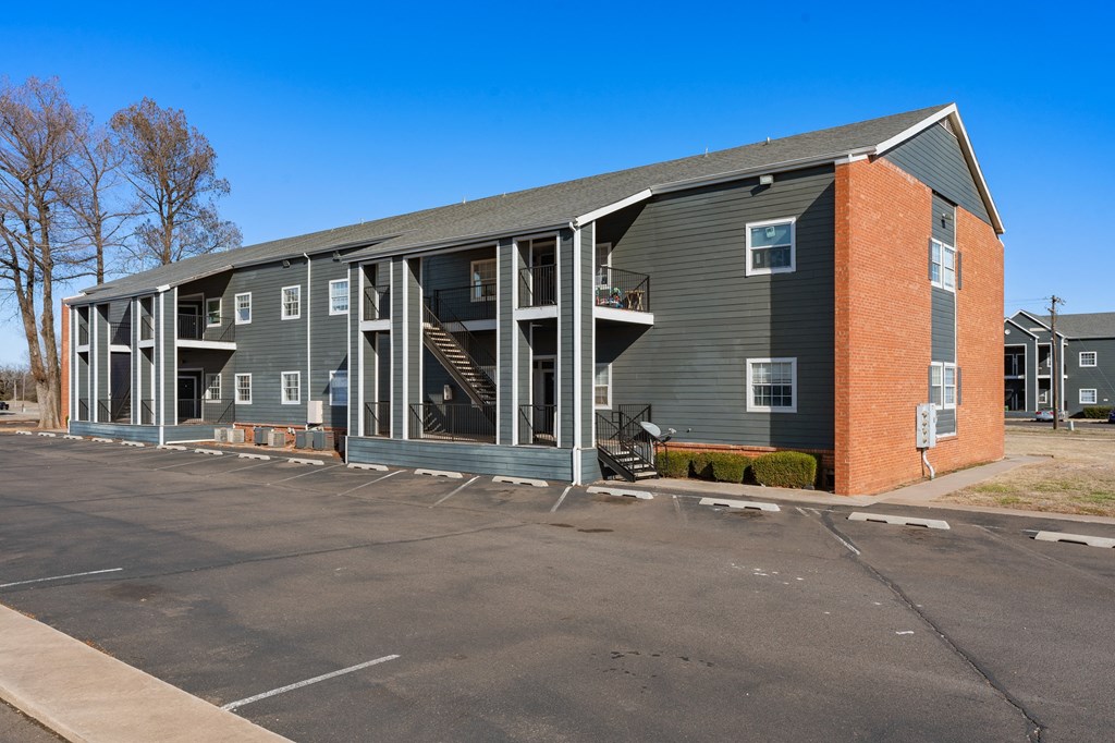 the exterior of a apartment building with a parking lot