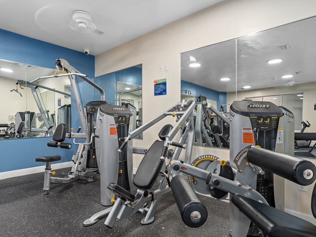 a gym with exercise equipment and mirrors in a building at Lake Lofts at Deerwood, Jacksonville, FL
