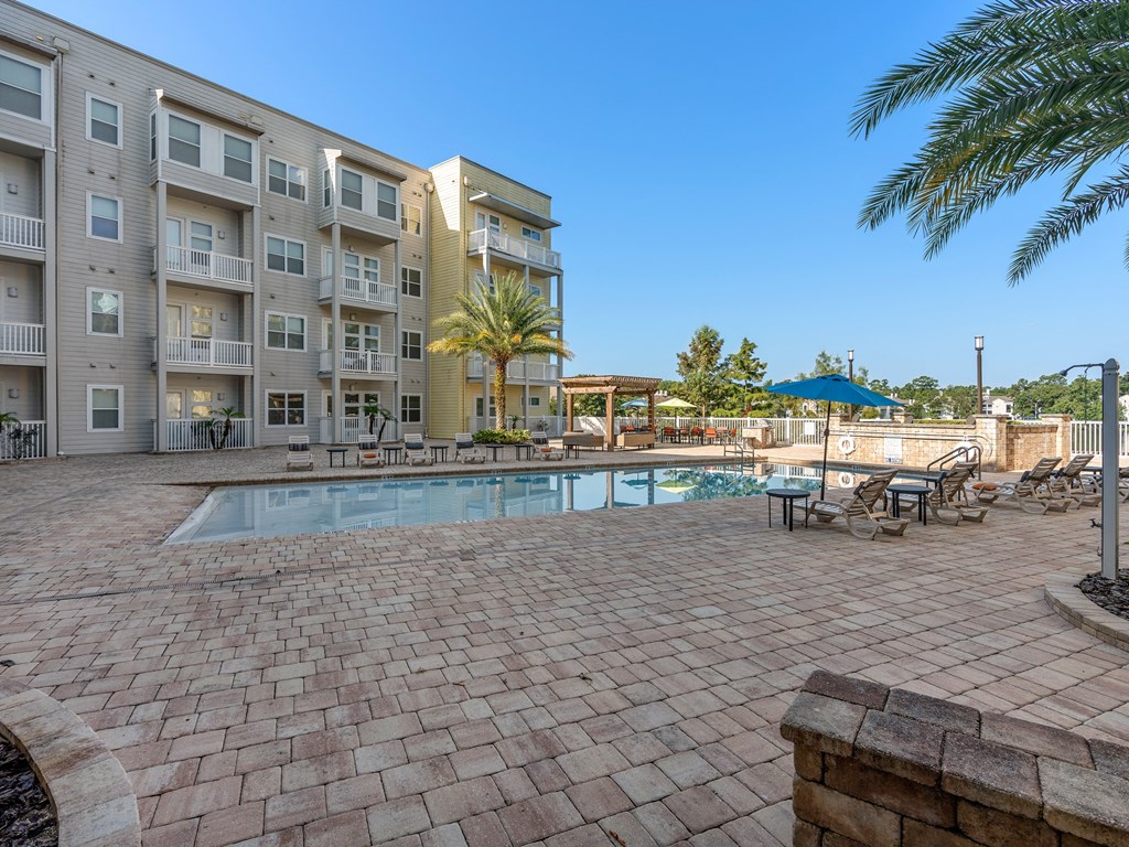 a swimming pool with an apartment building in the background at Lake Lofts at Deerwood, Jacksonville, 32216