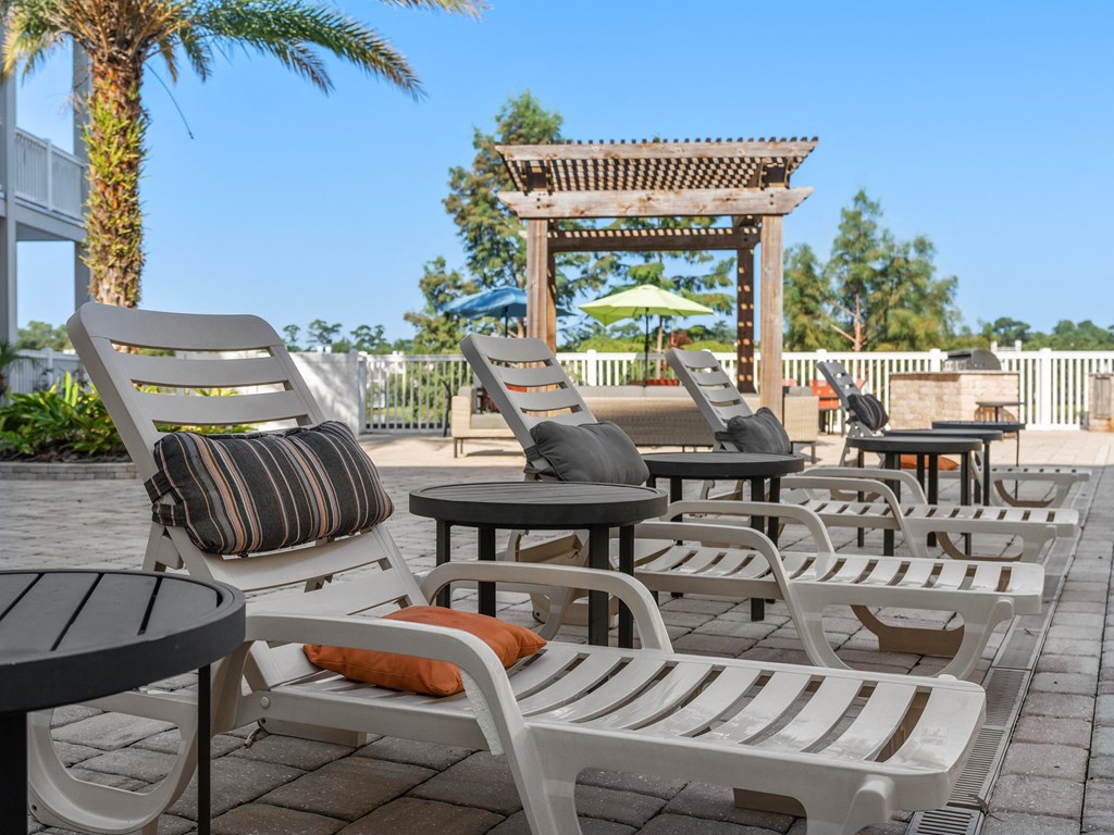 a group of lounge chairs and tables on a patio at Lake Lofts at Deerwood, Jacksonville, 32216