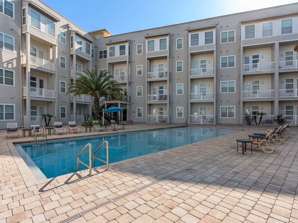 a swimming pool in front of an apartment building at Lake Lofts at Deerwood, Jacksonville, FL