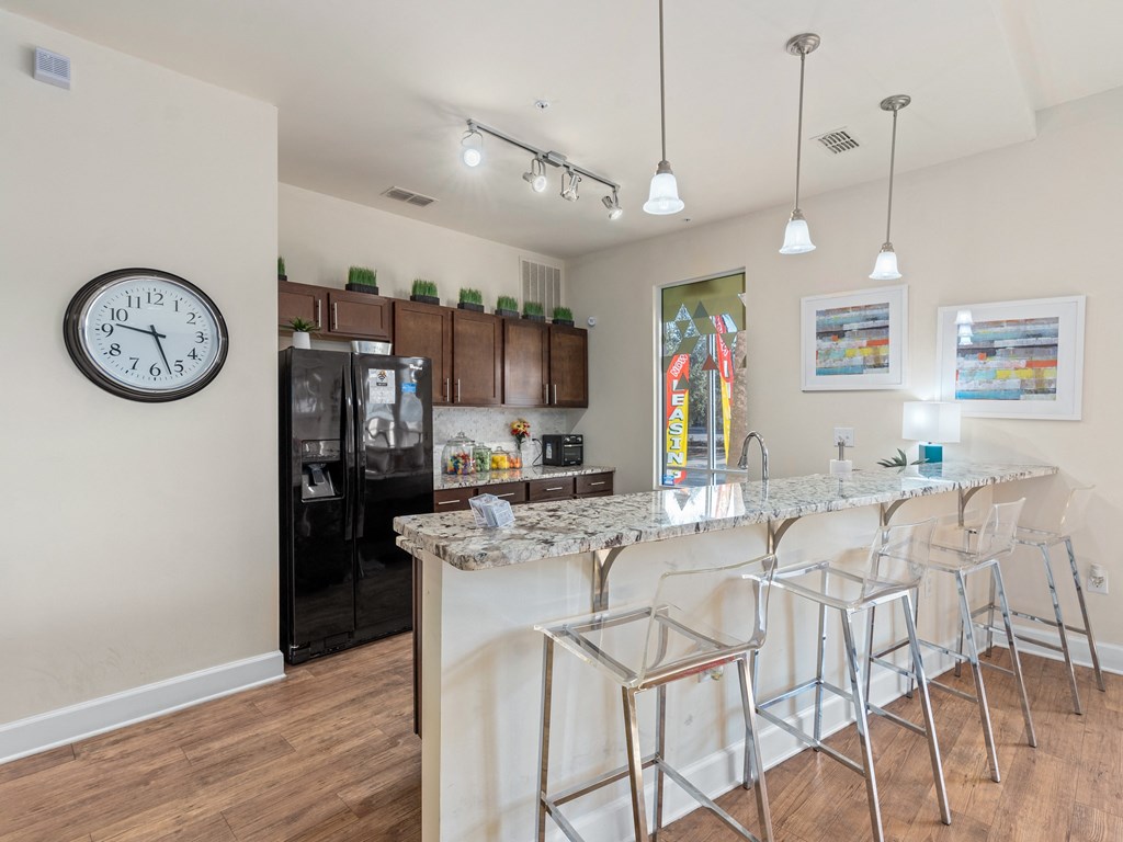 a kitchen with a marble counter top and a bar with stools at Lake Lofts at Deerwood, Jacksonville, FL
