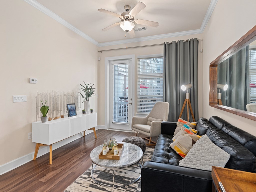 a living room with leather furniture and a ceiling fan at Lake Lofts at Deerwood, Jacksonville, Florida