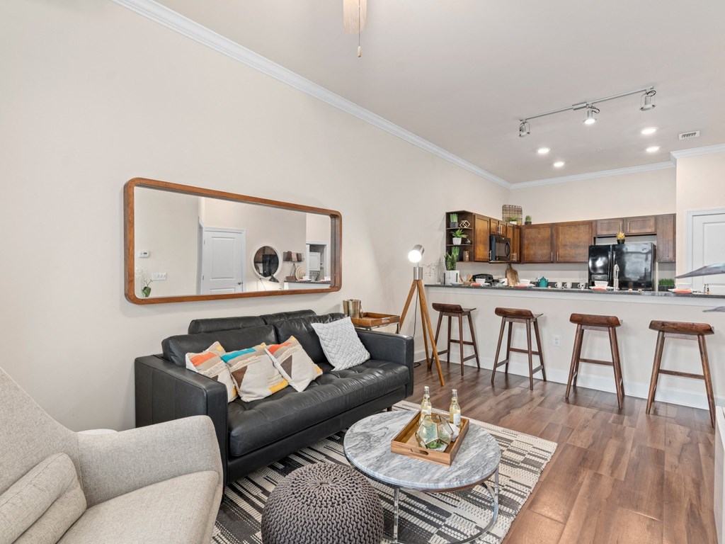a living room with a couch and a coffee table in front of a kitchen at Lake Lofts at Deerwood, Florida, 32216