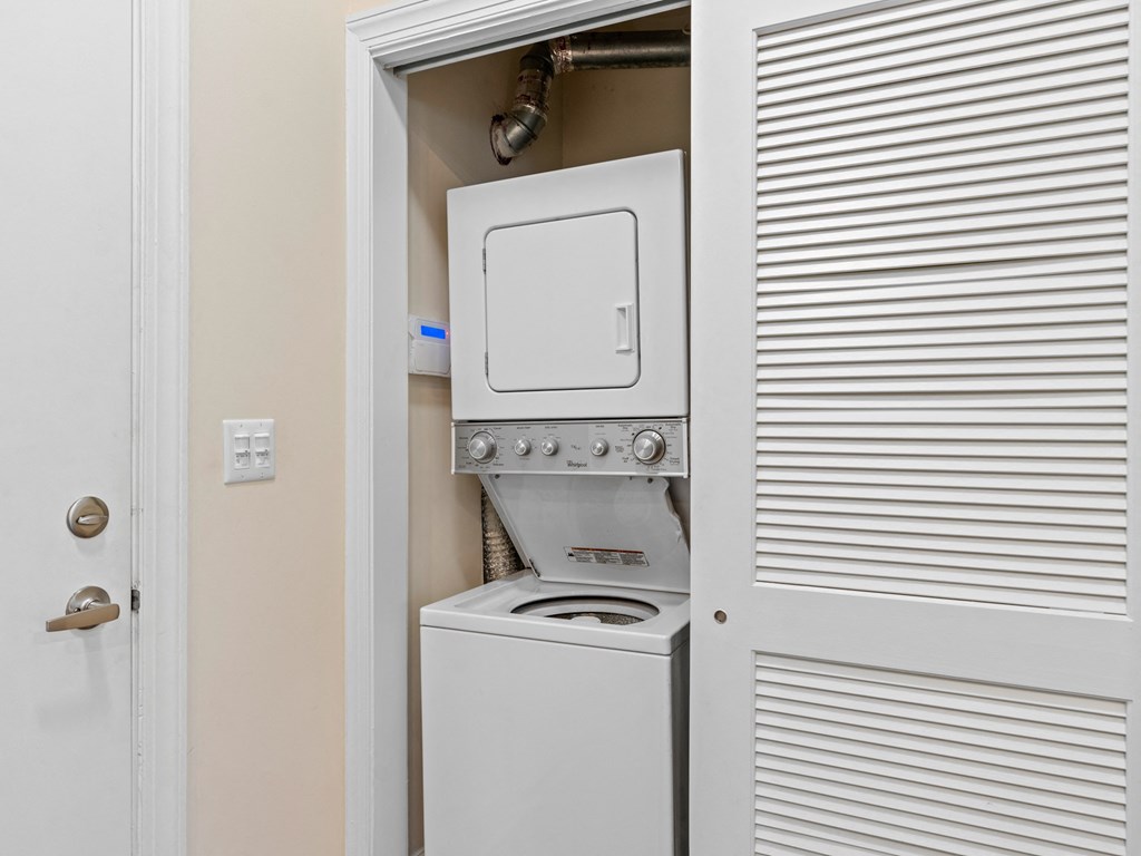 the laundry room has a washer and dryer and a white door at Lake Lofts at Deerwood, Jacksonville