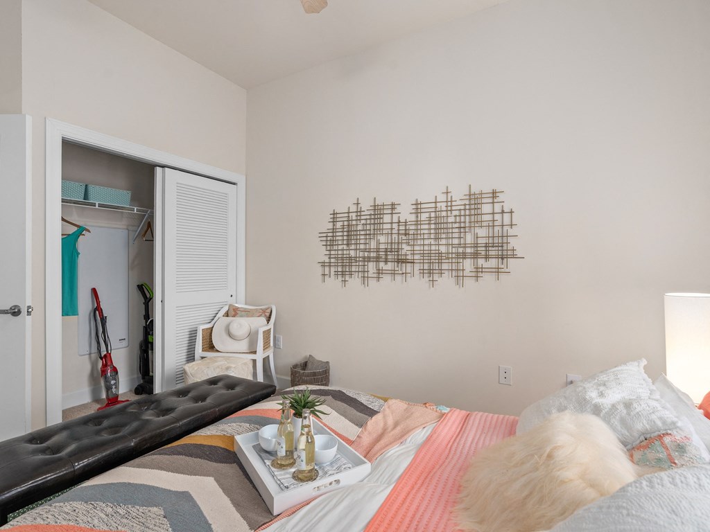 a bedroom with a bed and a white door to a closet at Lake Lofts at Deerwood, Jacksonville, Florida