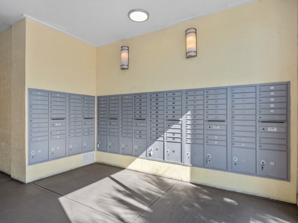 an empty locker room with blue lockers on the wall and a staircase at Lake Lofts at Deerwood, Jacksonville, FL, 32216