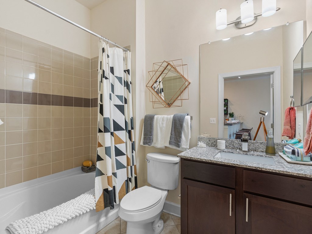 a bathroom with a shower toilet and sink and a mirror at Lake Lofts at Deerwood, Jacksonville, FL, 32216