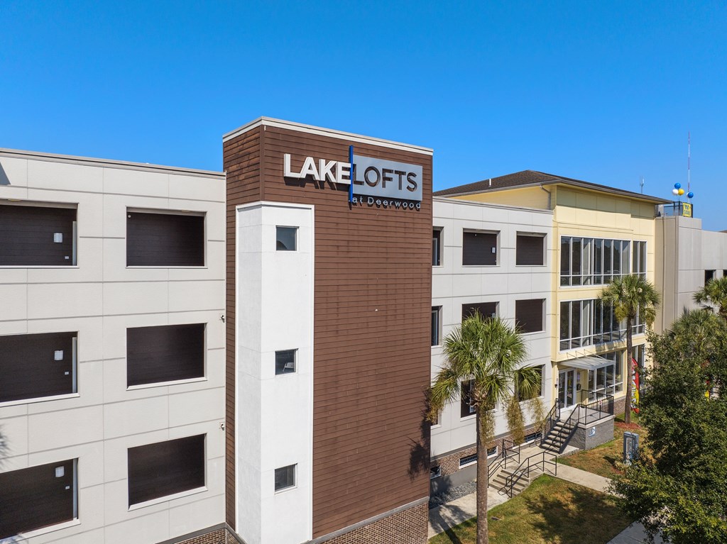 a view of the front of a building with a sign for lake acres apartments at Lake Lofts at Deerwood, Florida, 32216