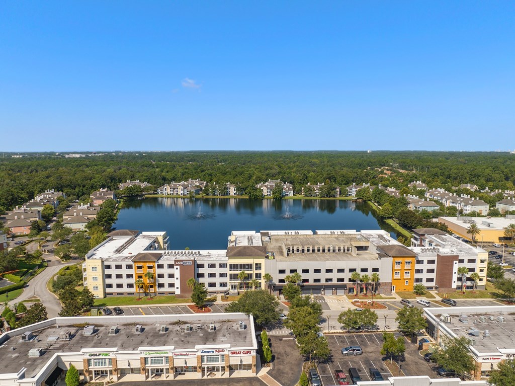 an aerial view of a building next to a lake at Lake Lofts at Deerwood, Jacksonville