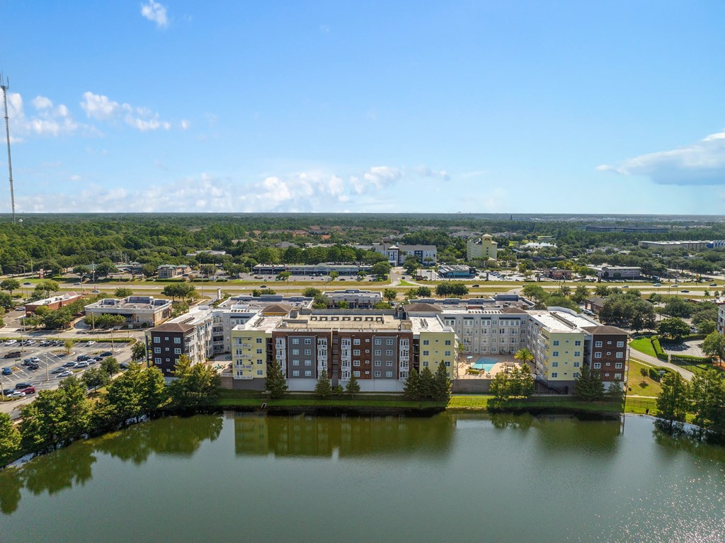 an aerial view of apartment buildings near a body of water at Lake Lofts at Deerwood, Jacksonville