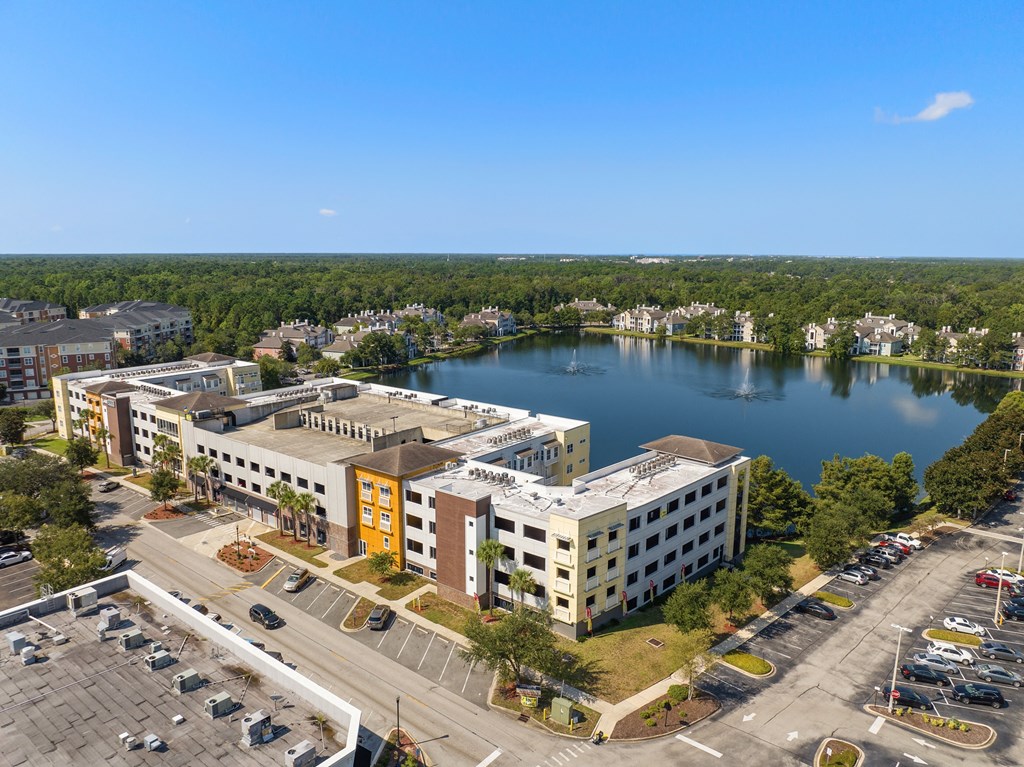 an aerial view of a building next to a lake at Lake Lofts at Deerwood, Jacksonville, FL, 32216