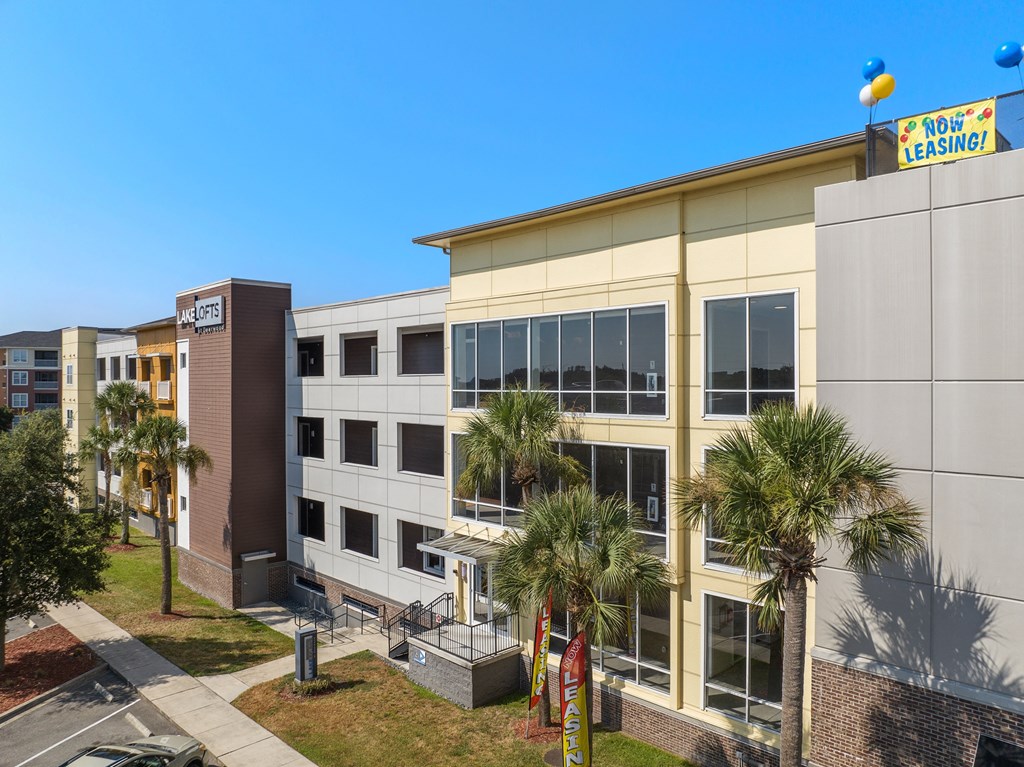 a large building with palm trees in front of it at Lake Lofts at Deerwood, Florida, 32216