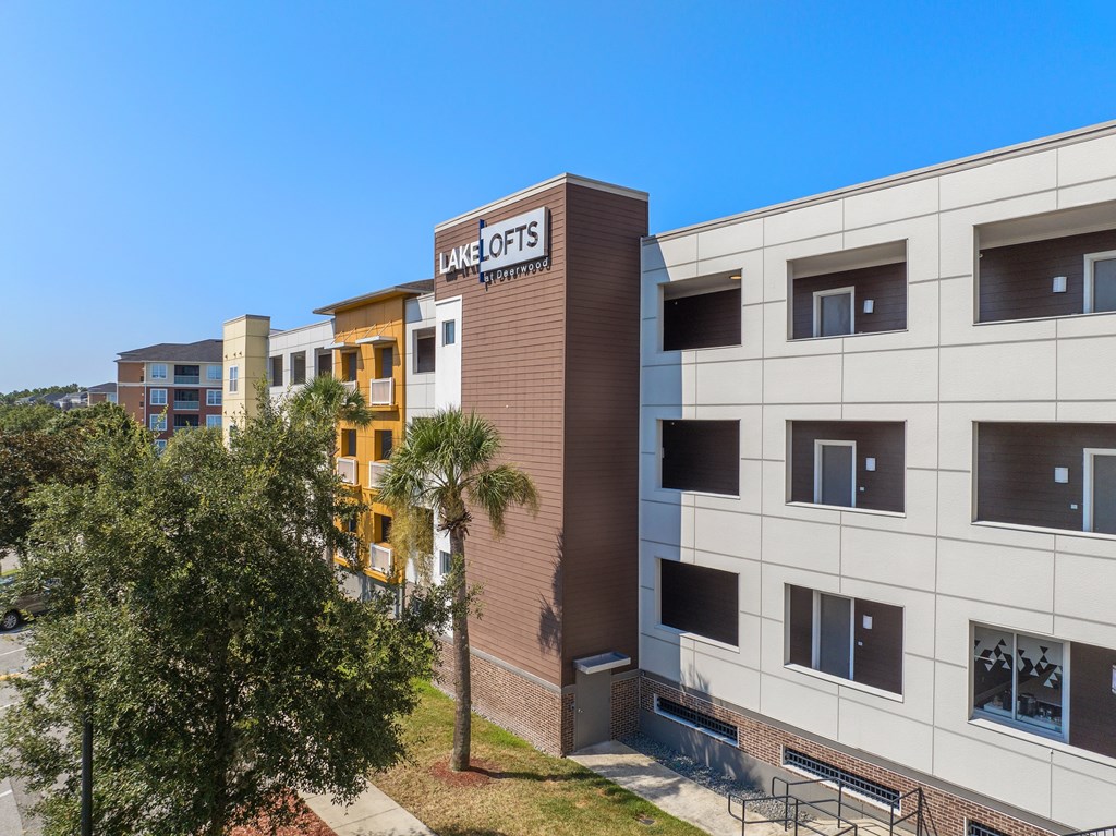 a building with the ace properties logo on the side of it at Lake Lofts at Deerwood, Jacksonville, FL