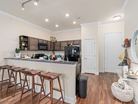 a kitchen with a bar and a counter with stools