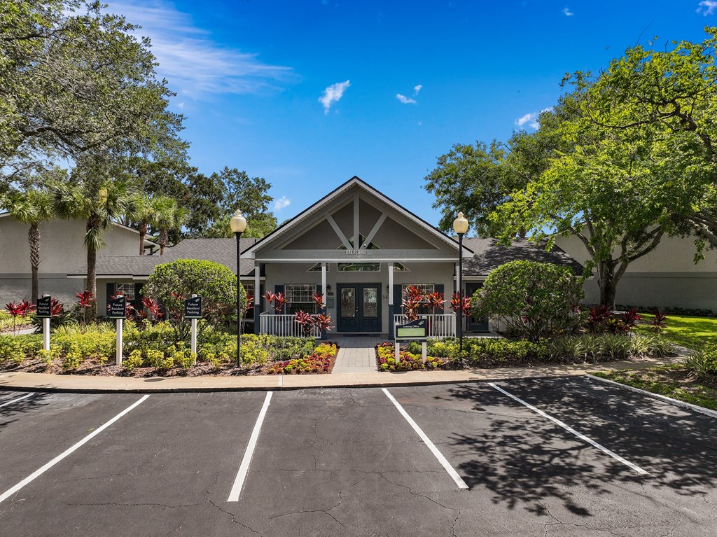 the front of a building with a parking lot and trees at Oak Reserve at Winter Park, Winter Park