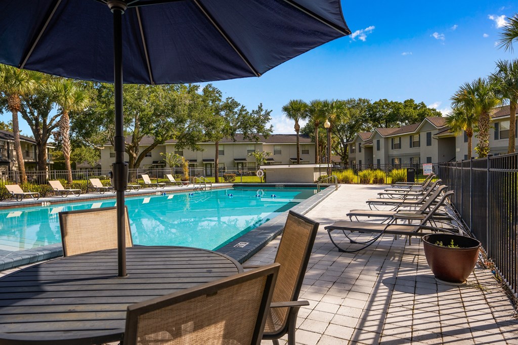 our apartments have a resort style pool with tables and chairs at Oak Reserve at Winter Park, Winter Park, Florida