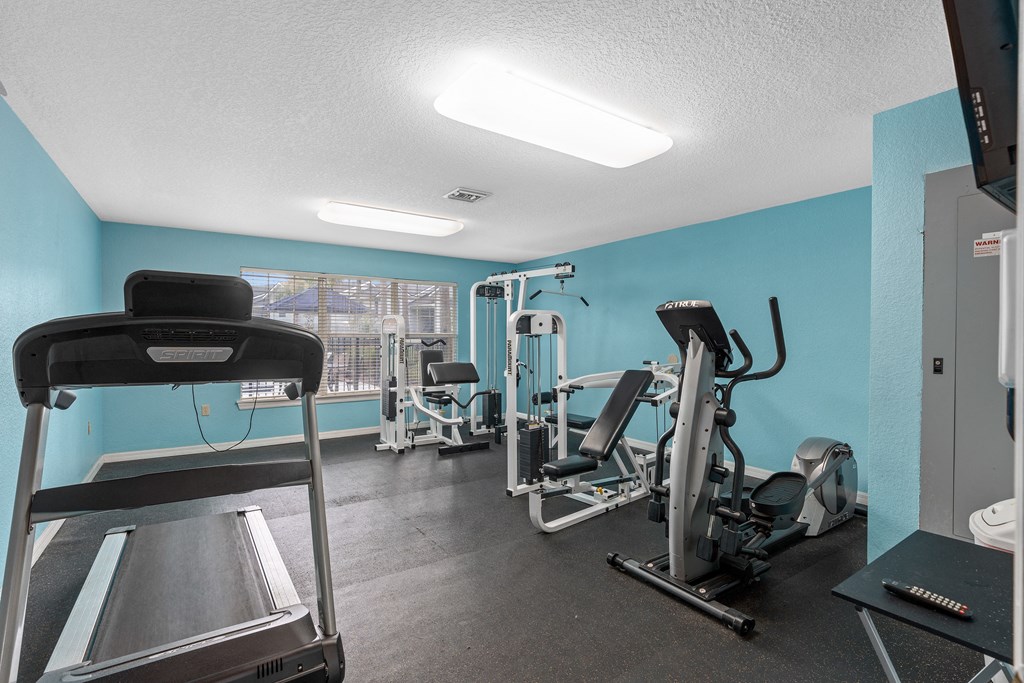 the gym has cardio machines and weights in it at the enclave at woodbridge apartments at Oak Reserve at Winter Park, Florida