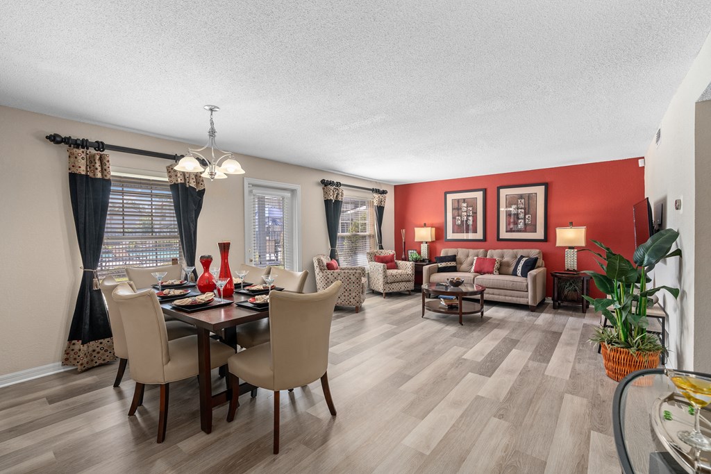 a living room and dining room with red walls and wooden floors at Oak Reserve at Winter Park, Winter Park, 32792