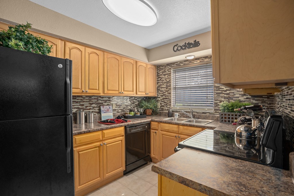 a kitchen with black appliances and wooden cabinets at Oak Reserve at Winter Park, Florida, 32792