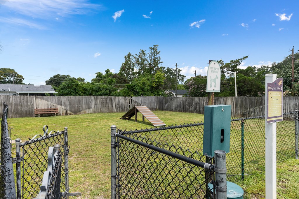 a park with a chain link fence and a seesaw in the grass at Oak Reserve at Winter Park, Winter Park, FL