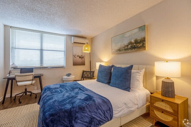 a bedroom with a bed and a desk with a chair  at Club at Emerald Waters, Hollywood, 33021