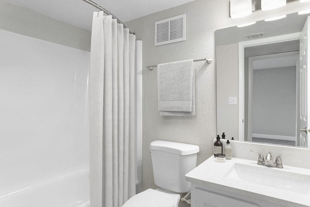 a white bathroom with a shower and a toilet and a sink at Lakeside Villas, Orlando, FL