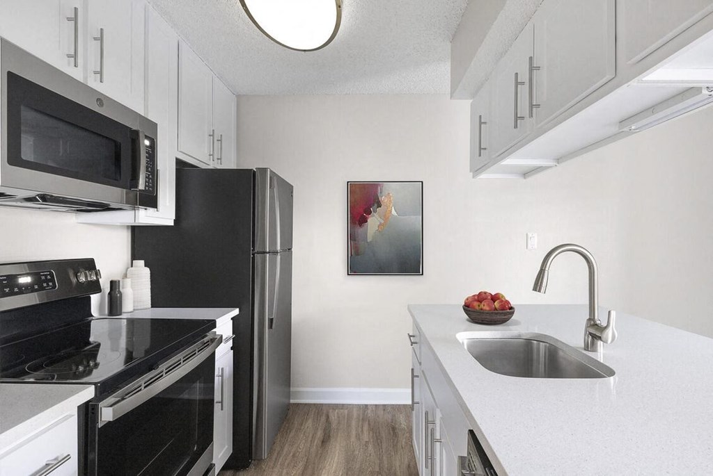a kitchen with black appliances and white cabinets at Lakeside Villas, Florida
